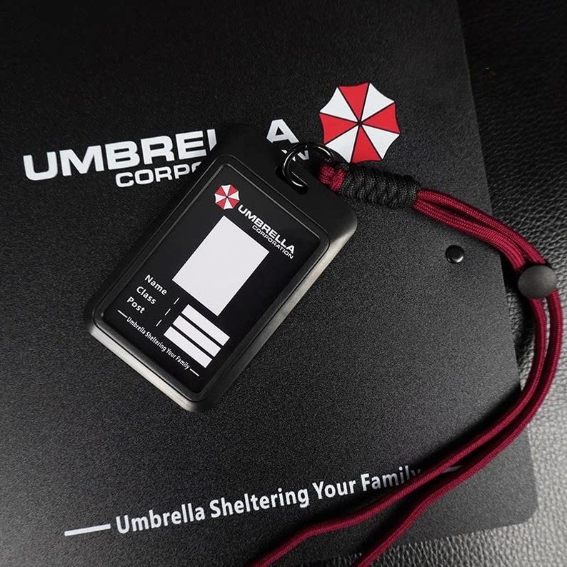 Umbrella badge holder with red rope strap on black folder, Resident Evil style ID cover for cosplay photos.