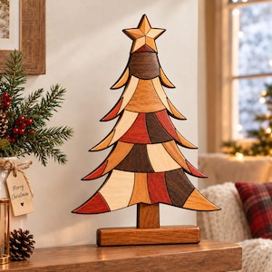 Könnte beinhalten: Eine dekorative Weihnachtsbaumskulptur aus Holz mit einem geometrischen Patchwork-Design in verschiedenen Braun-, Beige- und Rottönen. Der Baum ist mit einem Stern gekrönt und steht auf einem rechteckigen Holzsockel.