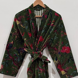 May include: A green velvet robe with a floral and bird pattern. The robe has a tie closure and long sleeves. The lining is striped. The colors include green, red, yellow, and blue.