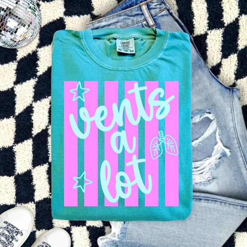 Teal Comfort Colors t-shirt with pink retro stripes and aqua lettering that says "vents a lot" with lungs graphic, styled in a flat lay with ripped jeans, sneakers, and disco ball. Great gift for respiratory therapist.