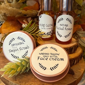 May include: A collection of skincare products, including facial cleanser, toner, sugar scrub, and face cream. The products are in small glass bottles and round tins with labels. The labels feature botanical illustrations and product names.