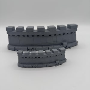 Pode incluir: Dois segmentos de parede cinzentos, curvos e impressos em 3D, com topos ameados e bases com textura de pedra. A secção de parede maior tem sete ameias, enquanto a secção frontal mais pequena tem seis.