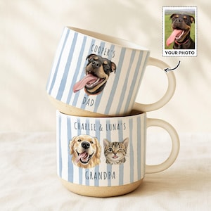 May include: Two ceramic mugs with blue and white vertical stripes. One mug features a dog illustration with the text "COOPER'S DAD". The other mug has illustrations of a dog and a cat, with the text "CHARLIE & LUNA'S GRANDPA".