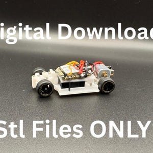 Könnte beinhalten: Ein kleines, weißes Rennwagenmodell mit schwarzen Rädern und verschiedenen elektronischen Komponenten. Der Text "Digital Download" und "*Stl Files ONLY*" ist in Weiß dargestellt. Das Auto steht vor einem dunklen Hintergrund.