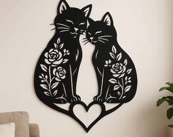 May include: Black metal wall art featuring two cats with floral designs, seated on a heart. The cats are facing each other, with closed eyes and whiskers. The floral designs include roses and leaves.
