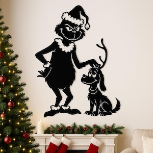 Puede incluir: Arte mural de silueta negra con un personaje con gorro de Papá Noel y un perro con cuernos. El arte temático de El Grinch se exhibe sobre una chimenea decorada con guirnaldas, calcetines y un árbol de Navidad.