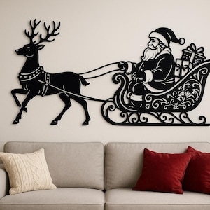 Può includere: Arte da parete in metallo nero raffigurante Babbo Natale su una slitta trainata da una renna. La renna ha grandi corna ed è attaccata alla slitta. Babbo Natale tiene le redini e la slitta è piena di regali. Una decorazione natalizia festosa.