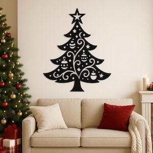 May include: A black, decorative Christmas tree wall art piece with a star on top. The tree features cut-out ornaments and swirls. The tree is mounted on a cream-colored wall above a beige sofa with red and cream pillows.