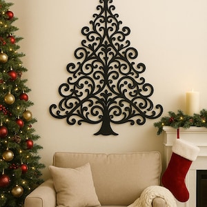 Op de afbeelding: Een zwarte, decoratieve kerstboom van hout is aan een crèmekleurige muur bevestigd. De boom heeft een ster bovenop en een gedetailleerd, wervelend ontwerp. Een versierde kerstboom, een bank en een open haard met een kous bevinden zich ook in de kamer.