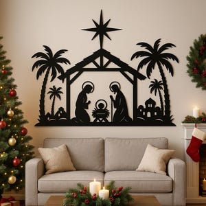 May include: Black metal wall art depicting the Nativity scene, including the Holy Family, a star, palm trees, and a stable. The artwork is mounted above a sofa, with a Christmas tree and wreath visible in the background. A festive holiday decoration.
