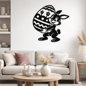 Könnte beinhalten: Schwarzes Metall-Osterhasen-Wandbild, das ein großes, verziertes Ei hält. Das Ei hat Blumen- und Wellenmuster. Der Hase lächelt und trägt eine Fliege. Diese Dekoration ist perfekt für Ostern.