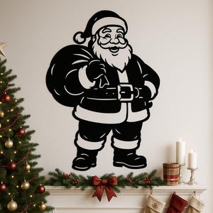 Puede incluir: Decoración de pared de Papá Noel en blanco y negro. La alegre figura se representa con una barba completa, un saco de regalos y un cinturón con una hebilla grande. La decoración está colocada en una pared blanca, con un árbol de Navidad y una chimenea en el fondo.