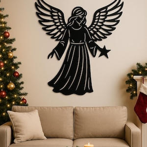Puede incluir: Decoración de pared de metal negro con un ángel con las alas extendidas, sosteniendo una estrella. El ángel está montado en una pared beige sobre un sofá. Un árbol de Navidad y decoraciones festivas son visibles en el fondo.