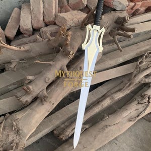 May include: A decorative sword with a gold-colored hilt and a silver blade. The hilt has a black grip and a stylized design. The sword is displayed on a wooden surface. The text "MYTHQUEST FORGE" is visible in the image.