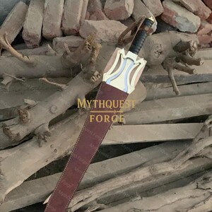 May include: A sword with a brown leather sheath. The sword has a black handle and a gold-colored crossguard with blue and white accents. The sheath is a dark brown color and has a leather strap.