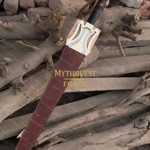 May include: A sword with a gold-colored hilt and a black handle is partially sheathed in a brown leather scabbard. The sword's design includes a light blue accent. The scabbard is stitched with white thread. The text "MYTHQUEST FORGE" is visible.