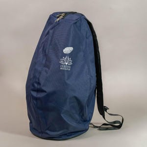 May include: A navy blue backpack with a black strap and a silver zipper. The backpack has a white logo and the text "ISKCON MAYAPUR" printed on the front. The backpack is made of a durable material and is designed to carry items.