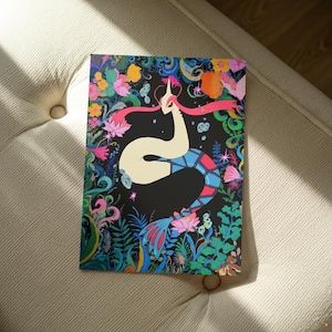 Peut inclure: Une impression d'art colorée représentant une créature stylisée avec un long corps blanc et un couvre-chef rose, sur fond noir. L'œuvre est entourée de fleurs et de feuillages vibrants dans des tons de rose, bleu, jaune et vert.