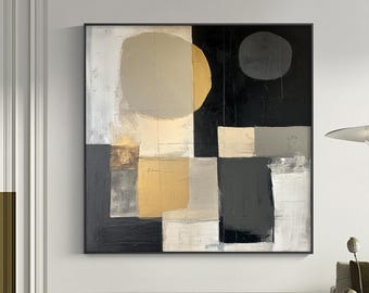 Op de afbeelding: Abstract vierkant schilderij met een zwarte lijst. Het kunstwerk toont geometrische vormen in tinten goud, grijs, zwart en wit. De compositie omvat een grote, afgeronde vorm en een kleinere cirkel tegen een zwarte achtergrond.