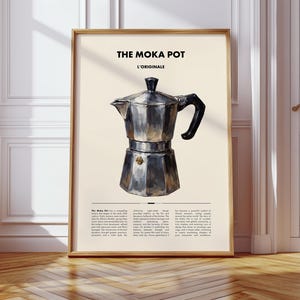 May include: A framed print with a watercolour illustration of a Moka pot. The pot is silver with a black handle and spout, set against a cream background. The text "THE MOKA POT L'ORIGINALE" is at the top.