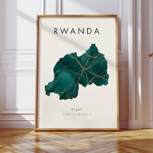 May include: Framed art print featuring a map of Rwanda in shades of teal and gold. The word "RWANDA" is printed in black at the top. The city of Kigali and its coordinates are printed at the bottom. The artwork is displayed in a wooden frame.