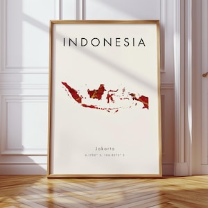 Può includere: Una stampa incorniciata con la parola "INDONESIA" in nero sopra una mappa rossa e oro del paese. La stampa include il testo "Jakarta" e le coordinate sotto la mappa. La stampa è in una cornice di legno, ideale per l'arredamento.