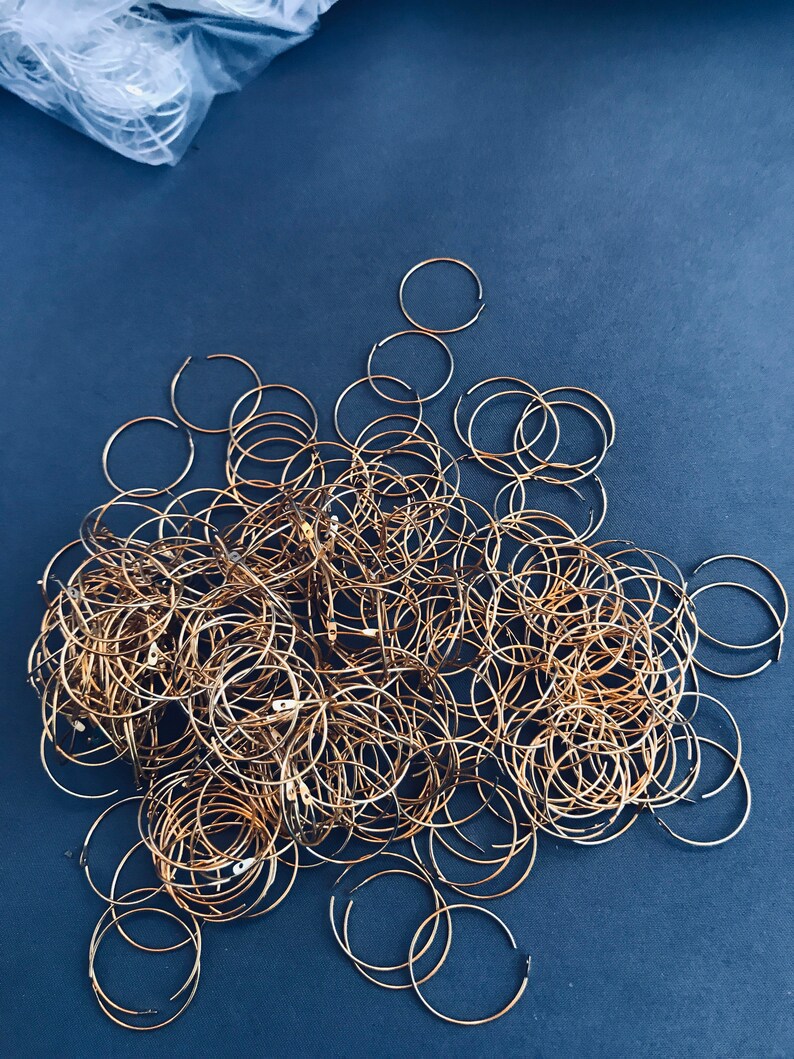 Op de afbeelding: Een grote stapel gouden metalen hoepels of ringen op een donkerblauwe achtergrond.