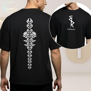 May include: Black t-shirt featuring a white graphic on the back and a smaller design on the front. The back design is a vertical, symmetrical pattern. The front design includes the word "Cyberpunk".