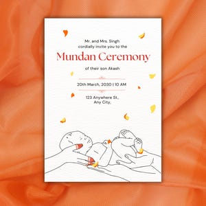 Könnte beinhalten: Eine weiße Einladungskarte für eine Mundan-Zeremonie mit rotem und schwarzem Text. Die Karte enthält Datum, Uhrzeit und Adresse. Eine Strichzeichnung eines Babys in Händen befindet sich unten. Der Hintergrund ist orange.
