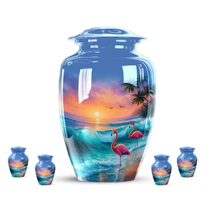 May include: A large, blue cremation urn with a glossy finish, featuring a vibrant beach scene with a sunset, ocean waves, palm trees, and two pink flamingos. Smaller matching keepsake urns are also visible.