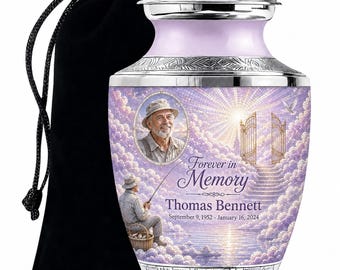 May include: A lavender cremation urn with a silver lid and base, featuring a portrait of a man in a hat, a fishing scene, and a stairway to heaven. The text reads Forever in Memory, Thomas Bennett, September 9, 1952 - January 16, 2024.