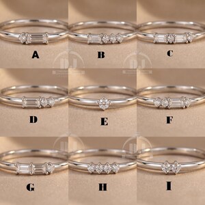 May include: Nine silver rings with different gemstone arrangements. Designs include a single solitaire, multiple stones, and a baguette-cut centre stone. The rings are displayed on a neutral background. Each ring is a delicate piece of jewellery.