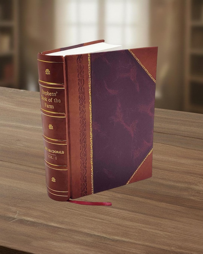 May include: A hardcover book titled "Stephens' Book of the Farm, Vol. I" with a burgundy cover and spine. The spine is a lighter brown with gold lettering and decorative accents. A red ribbon bookmark is visible.
