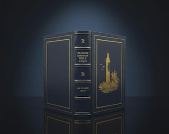 Op de afbeelding: Een marineblauw boek met gouden details, getiteld "The Complete Ethiopian Bible in English". De kaft toont een gouden illustratie van een vuurtoren en een schip. Het boek is open, met de rug en de binnenkant van de kaft zichtbaar.