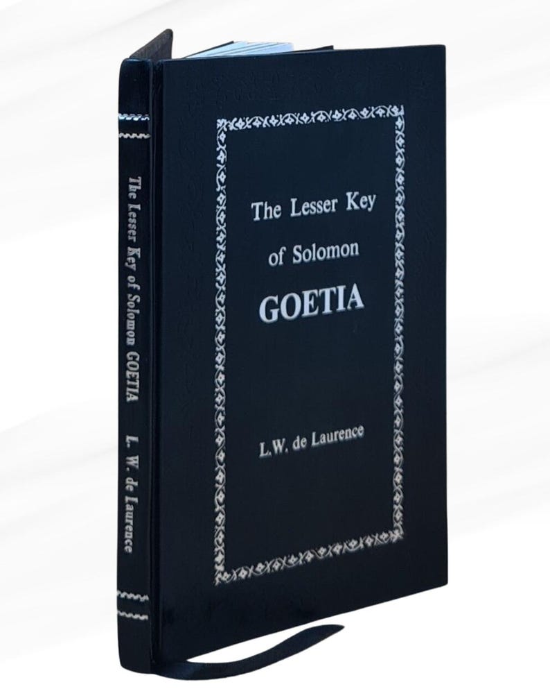 K&ouml;nnte beinhalten: Ein schwarzes Hardcover-Buch mit dem Titel "The Lesser Key of Solomon GOETIA" von L.W. de Laurence. Das Buch hat einen wei&szlig;en Text und eine dekorative Bord&uuml;re auf dem Einband. Der Titel und der Autor stehen auf dem Buchr&uuml;cken.