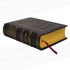 May include: A hardcover book titled "The Secret Teachings of All Ages" by Manly P. Hall. The book has a dark brown cover with gold lettering and gold-gilded pages. A red ribbon bookmark is inserted.