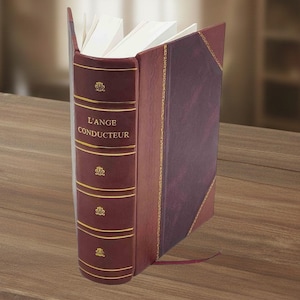 May include: A hardcover book with a burgundy leather cover and gold accents. The title "L'ANGE CONDUCTEUR" is embossed in gold on the spine. The book has a decorative design and a maroon bookmark.