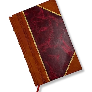 May include: A leather-bound journal with a burgundy cover and gold trim. The journal has a decorative border on the spine and a red ribbon bookmark. The cover is a rich brown color.