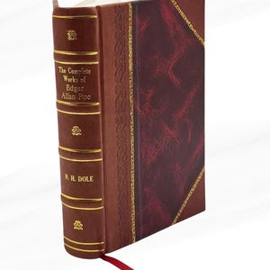 May include: A hardcover book titled "The Complete Works of Edgar Allan Poe" by N. H. Dole. The book has a brown leather spine with gold lettering and accents. The cover is a darker burgundy with a textured pattern and gold trim. A red ribbon bookmark is visible.
