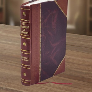 May include: A hardcover book titled "The Testament of Solomon" with a burgundy leather cover and gold lettering. The spine features decorative gold accents and the author's name. A red ribbon bookmark extends from the pages.