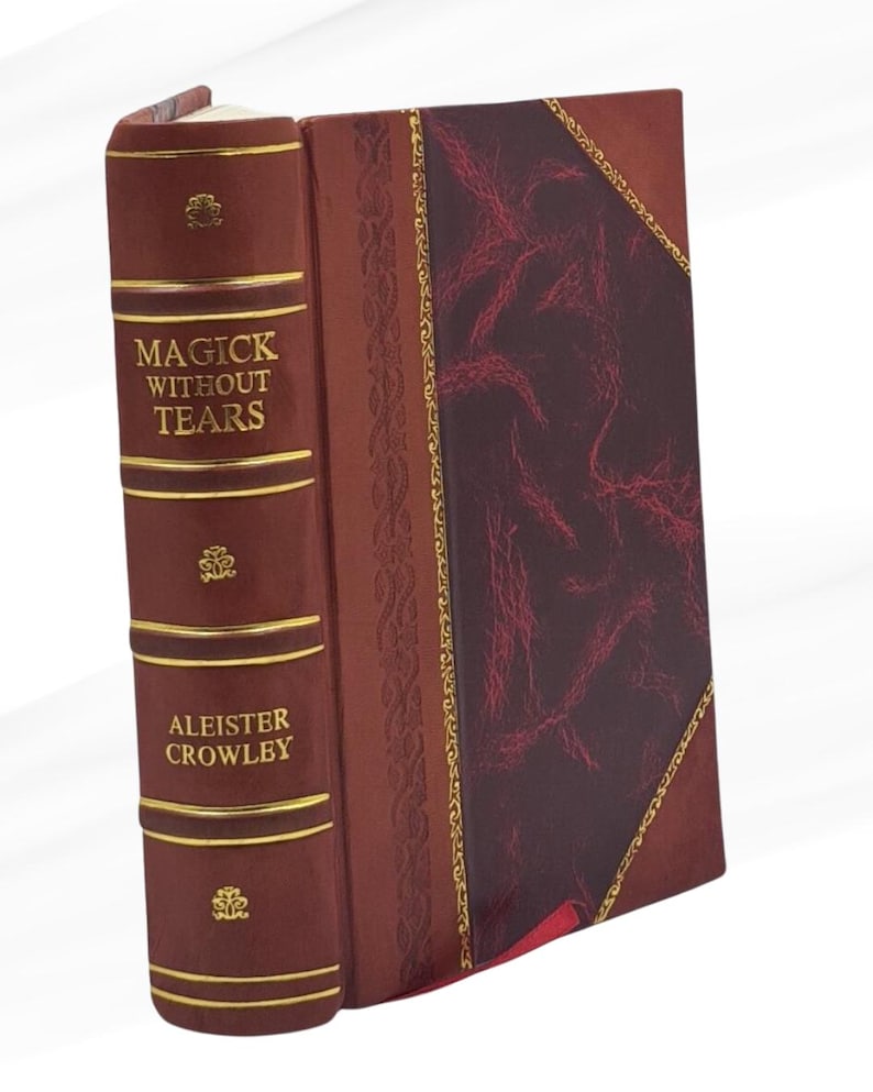 May include: A hardcover book titled "Magick Without Tears" by Aleister Crowley. The book has a dark red leather cover with gold accents and decorative patterns. The cover features a burgundy panel with a textured pattern.