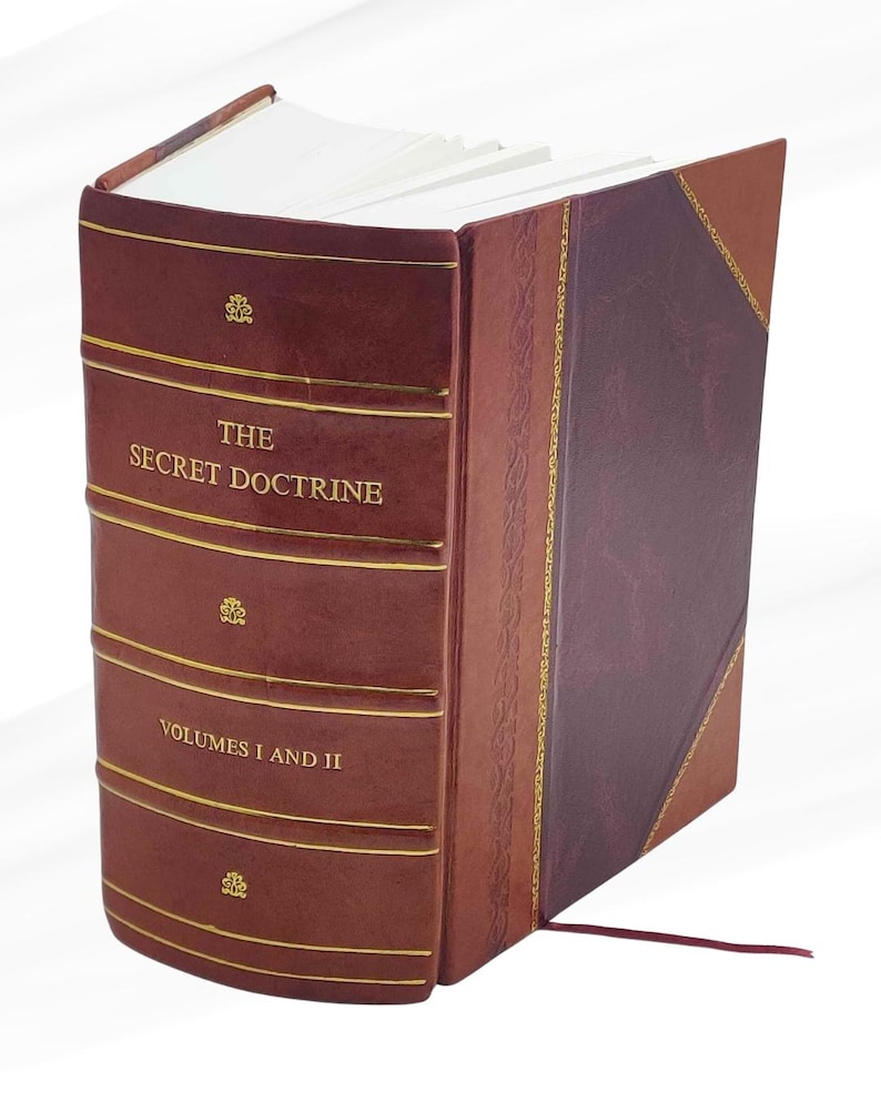 Puede incluir: Un libro encuadernado en cuero burdeos titulado "THE SECRET DOCTRINE, VOLUMES I AND II". Letras doradas y l&iacute;neas decorativas adornan la portada. El lomo est&aacute; dividido en secciones con detalles en relieve.