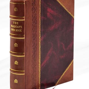 May include: A hardcover book titled "The Magician's Own Book" with a brown leather cover and gold accents. The book has a burgundy panel on the front cover and a red ribbon bookmark.