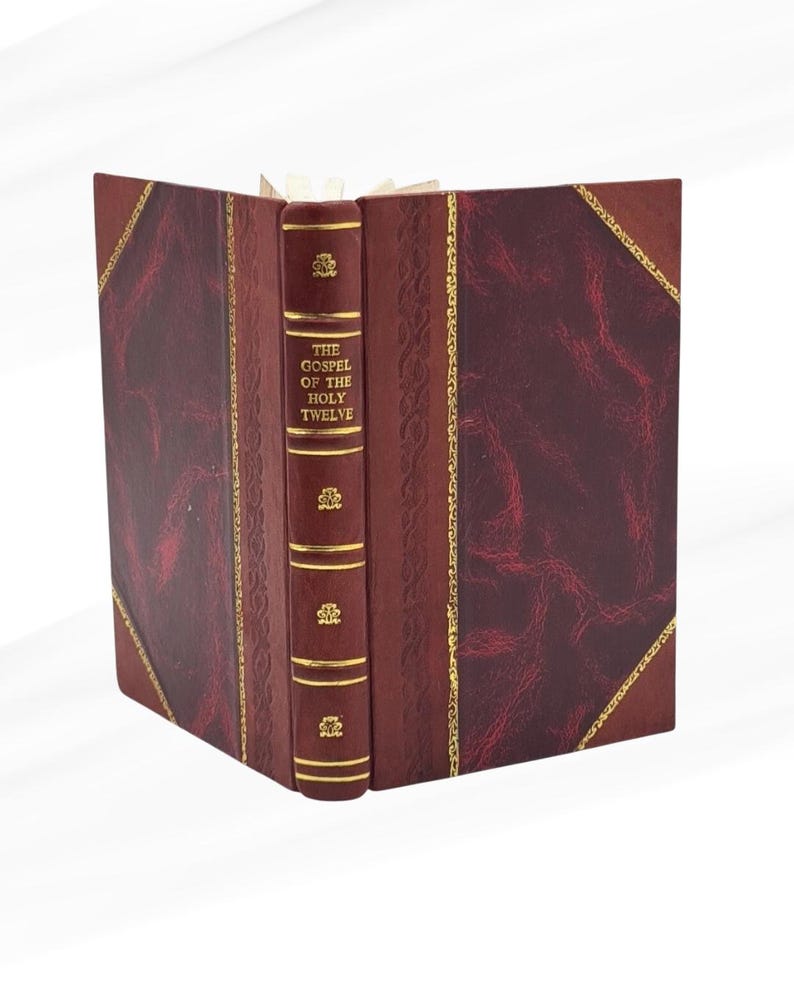 May include: A burgundy leather-bound book titled "The Gospel of the Holy Twelve". The spine features gold lettering and decorative gold detailing. The book is open, displaying the pages. The cover has a textured appearance.