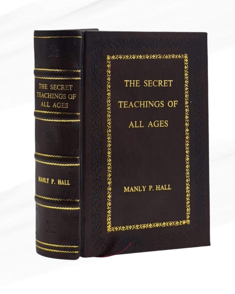 May include: A hardcover book titled "The Secret Teachings of All Ages" by Manly P. Hall. The book has a dark brown cover with gold lettering and decorative accents. The spine also features gold lettering.