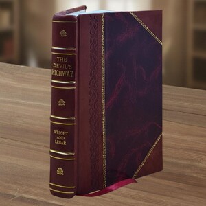 May include: A hardcover book titled "The Devil's Highway" with a burgundy leather cover and gold accents. The spine features the title and author's name, "Wright and Lebar," in gold lettering. A red ribbon bookmark is visible.