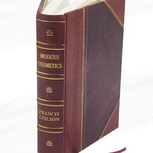 May include: A hardcover book titled "MODERN COSMETICS" by Francis Chilson. The book has a burgundy leather cover with gold lettering and accents. A burgundy ribbon bookmark is visible.