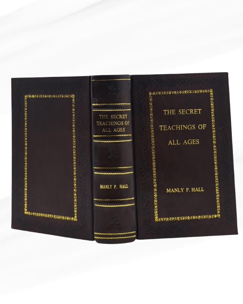May include: A hardcover book titled "The Secret Teachings of All Ages" by Manly P. Hall. The book has a dark brown cover with gold lettering and decorative gold trim. The spine is also dark brown with gold text.