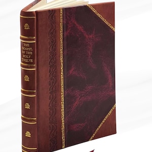 May include: A hardback book titled "The Gospel of the Holy Twelve." The book features a burgundy leather cover with gold detailing and a decorative spine. A burgundy ribbon bookmark is visible.