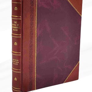 Puede incluir: Un libro de tapa dura titulado "THE BOOK OF CEREMONIAL MAGIC" de Arthur Edward Waite. El libro tiene una cubierta burdeos con ribete dorado y un lomo rojo oscuro. El lomo presenta el t&iacute;tulo y el nombre del autor en letras doradas.
